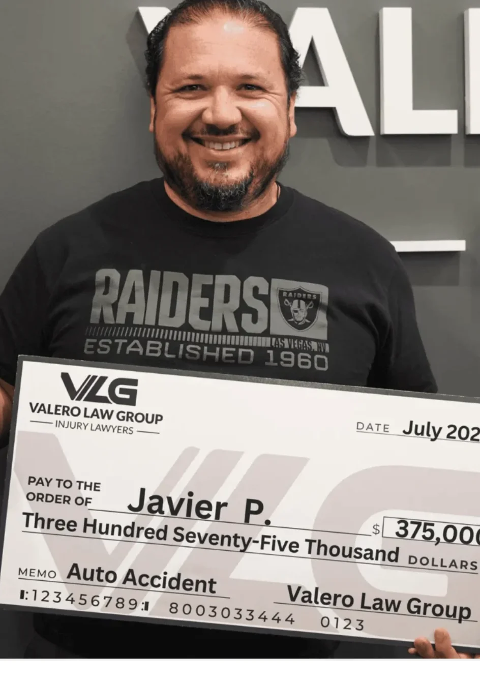 Cliente de Valero Law Group Javier P. sosteniendo un cheque de acuerdo de $375,000 por accidente de auto